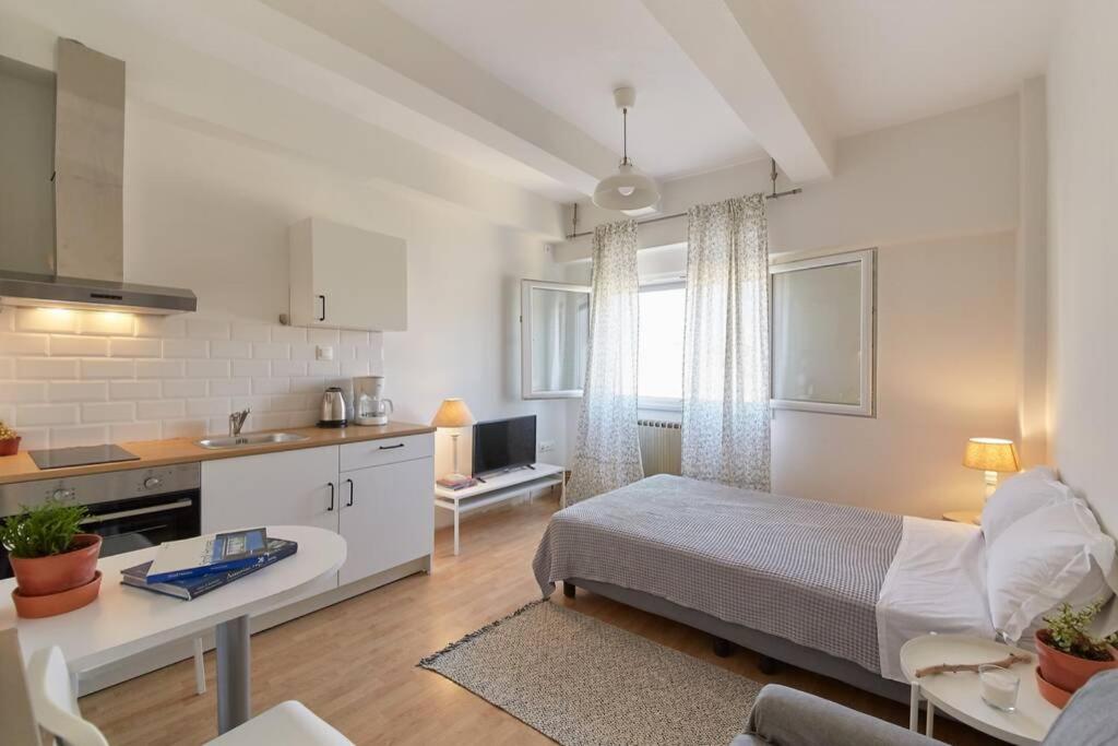 a kitchen and a bedroom with a bed and a table at Bright Lovely Central Studio in Thessaloniki in Thessaloniki
