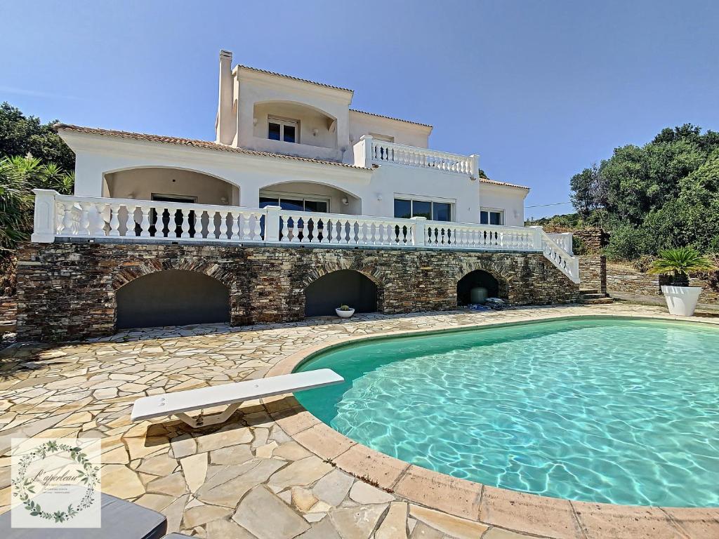 uma villa com piscina em frente a uma casa em Seaview villa Marlau em Macinaggio