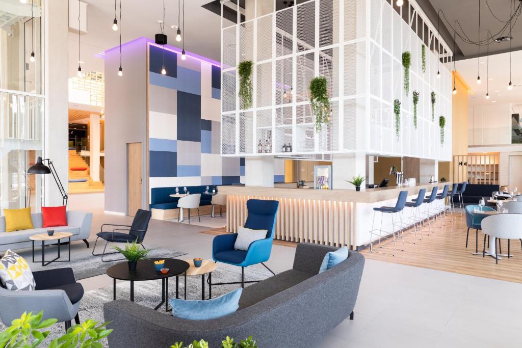 a lobby with chairs and tables and a bar at Holiday Inn Express Amsterdam - North Riverside by IHG in Amsterdam