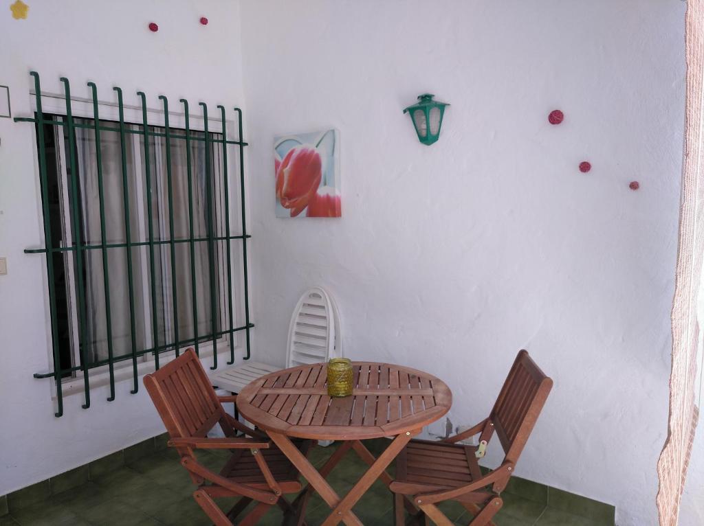 2 Calle las Azucenas في Playa del Aguila: طاولة وكراسي خشبية في الغرفة