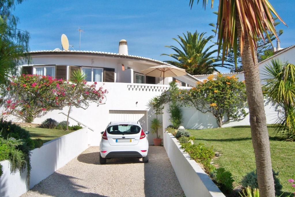 une voiture blanche garée devant une maison dans l'établissement Casa Catryn, à Luz