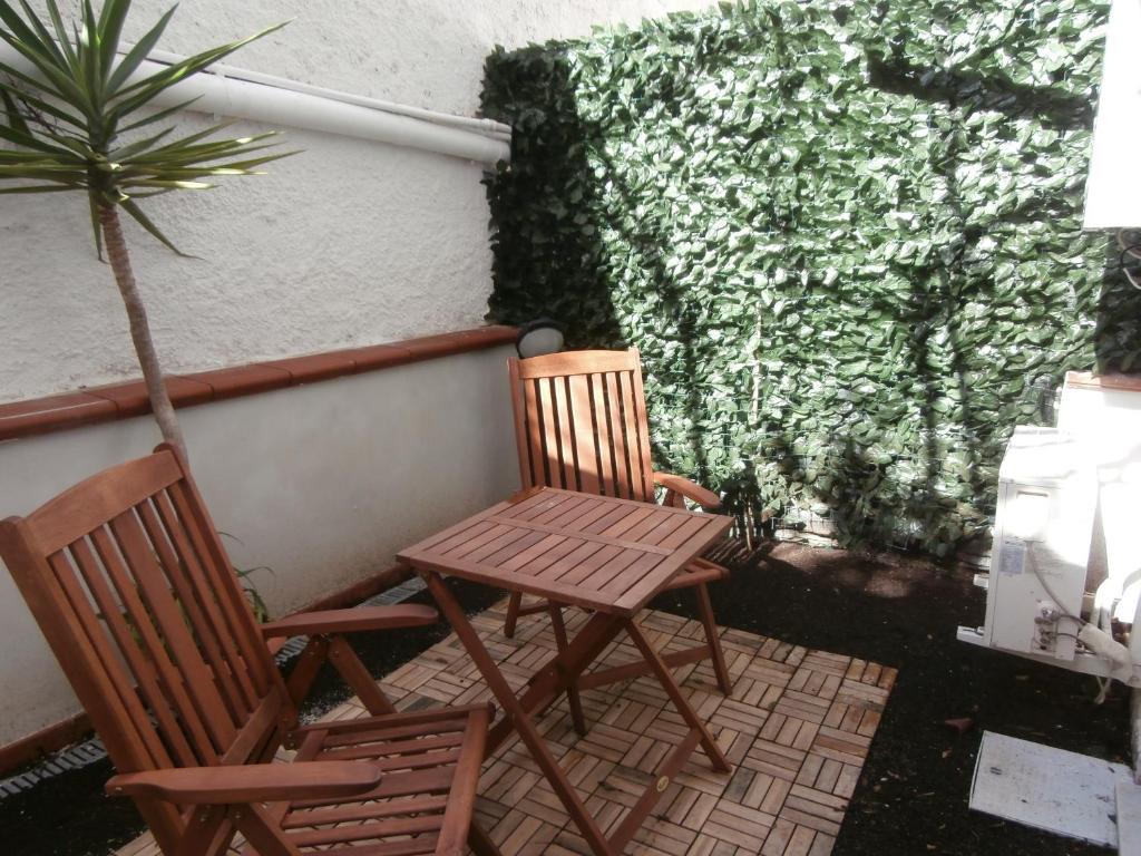 two chairs and a table on a patio with a plant at Busalacchi B&B in Mondello