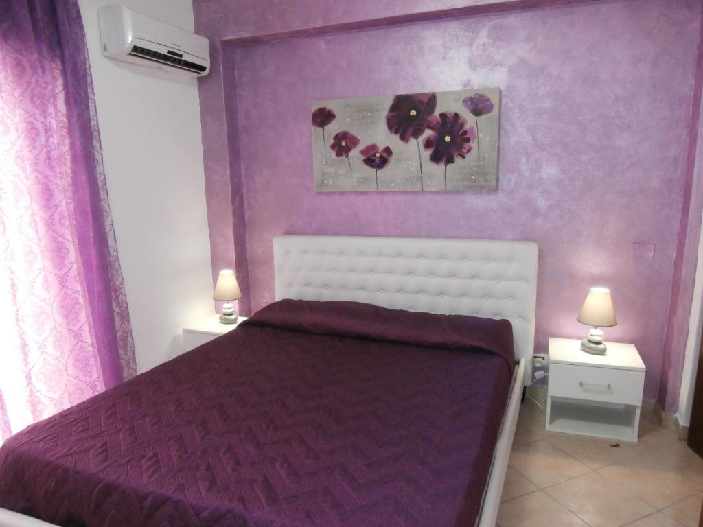 a purple bedroom with a bed and two night stands at Busalacchi B&B in Mondello