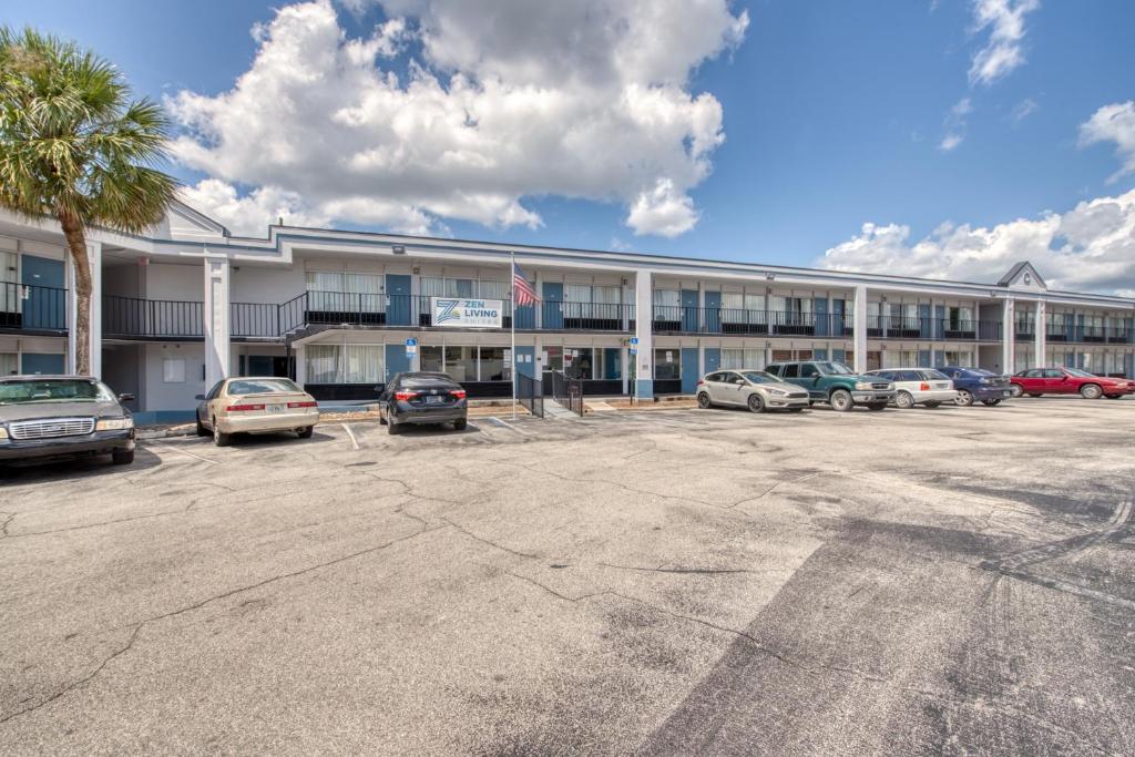 a large building with cars parked in a parking lot at Zen Living Suites Extended Stay - Jacksonville - Orange Park in Orange Park