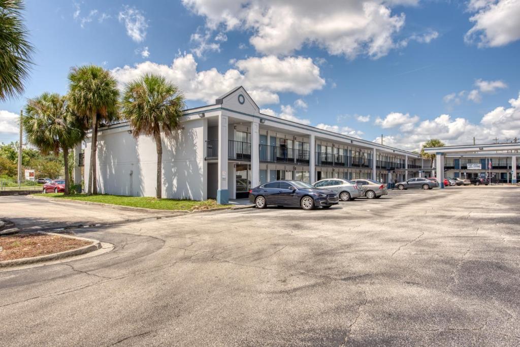 een groot gebouw met auto's geparkeerd op een parkeerplaats bij Zen Living Suites Extended Stay - Jacksonville - Orange Park in Orange Park