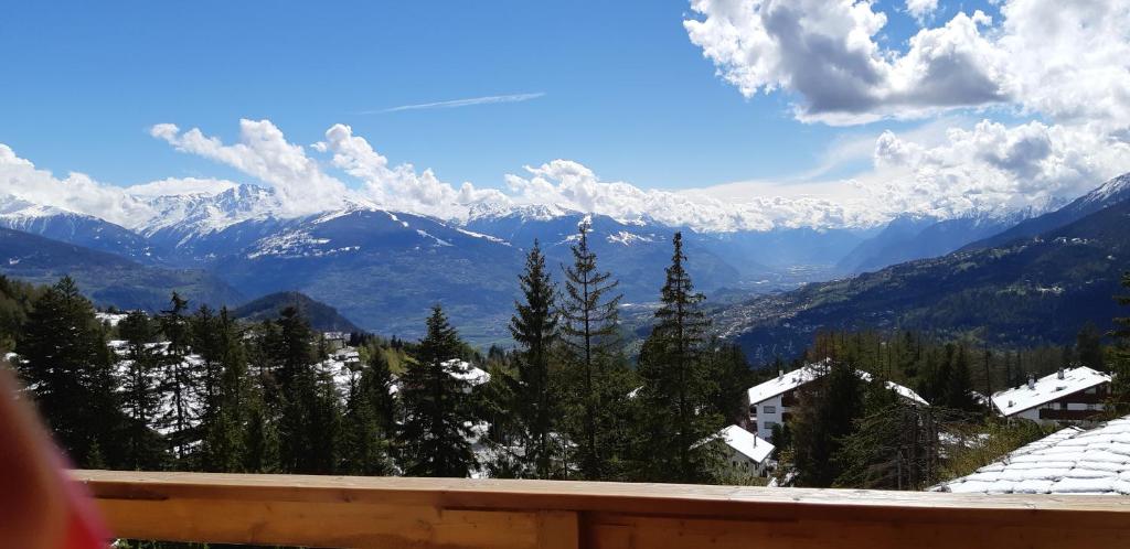 uma vista para as montanhas cobertas de neve a partir de uma varanda em LE NEVADA CRANS-MONTANA vue a vous couper le soufle em Crans-Montana