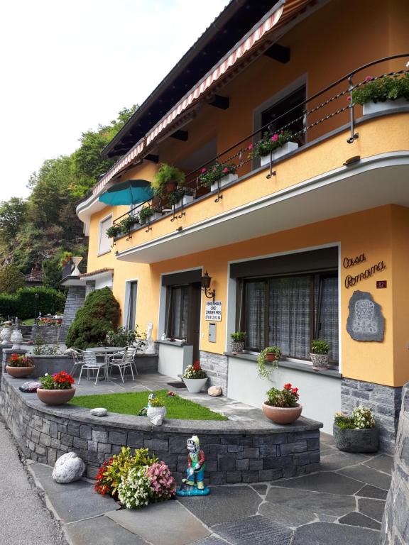 un bâtiment avec des fleurs devant lui dans l'établissement Casa Romana, à Someo