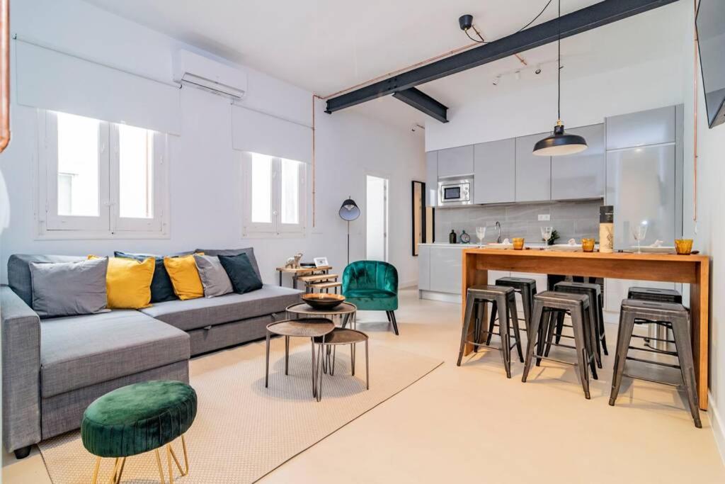 a living room with a couch and chairs and a kitchen at Exclusivo Apartamento en Chamberí Fernando El Católico by Batuecas in Madrid