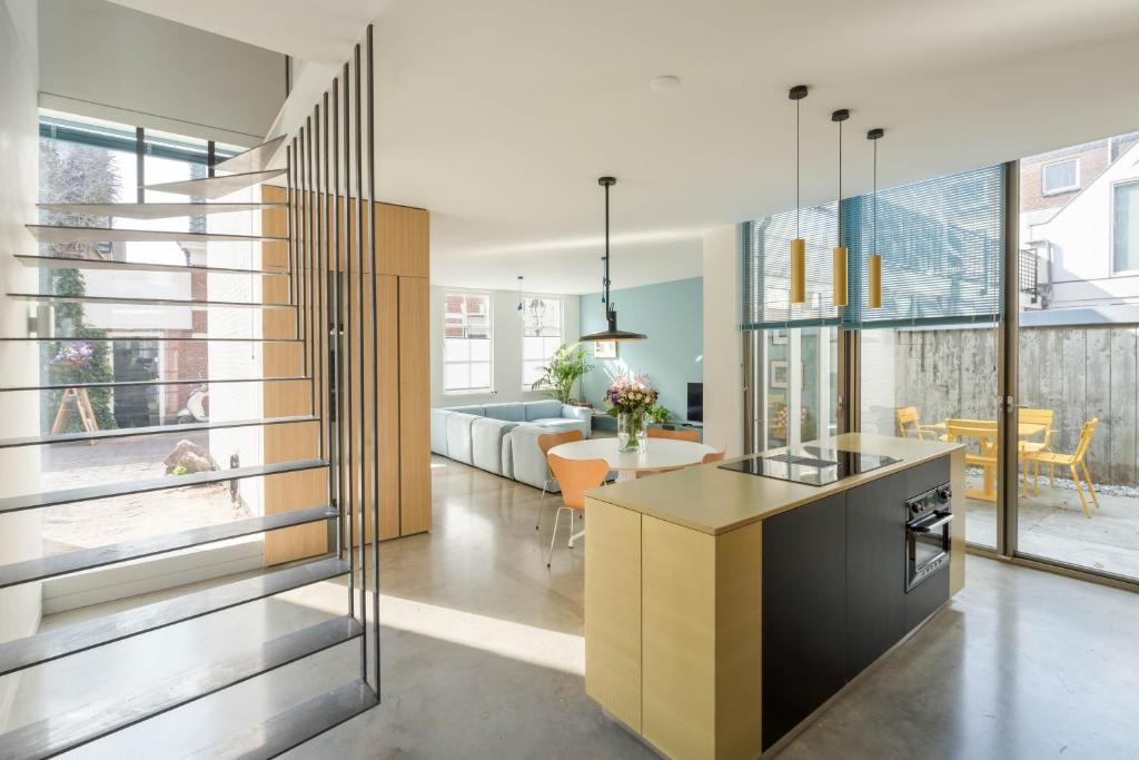 a kitchen and living room with glass walls at Kaewkong Surf Motel in Scheveningen