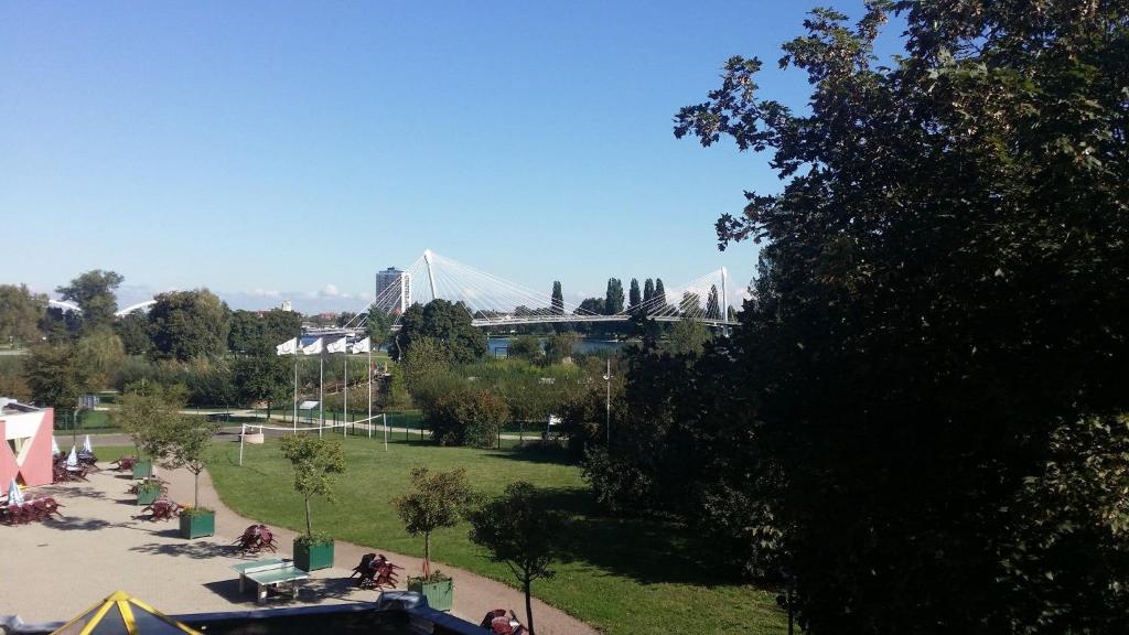 Blick auf einen Park mit einer Brücke im Hintergrund in der Unterkunft Auberge de Jeunesse HI Strasbourg 2 Rives in Straßburg