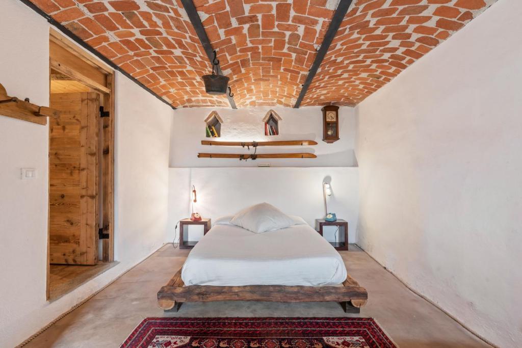 a bedroom with a bed and a brick ceiling at Greeneria in Guarene