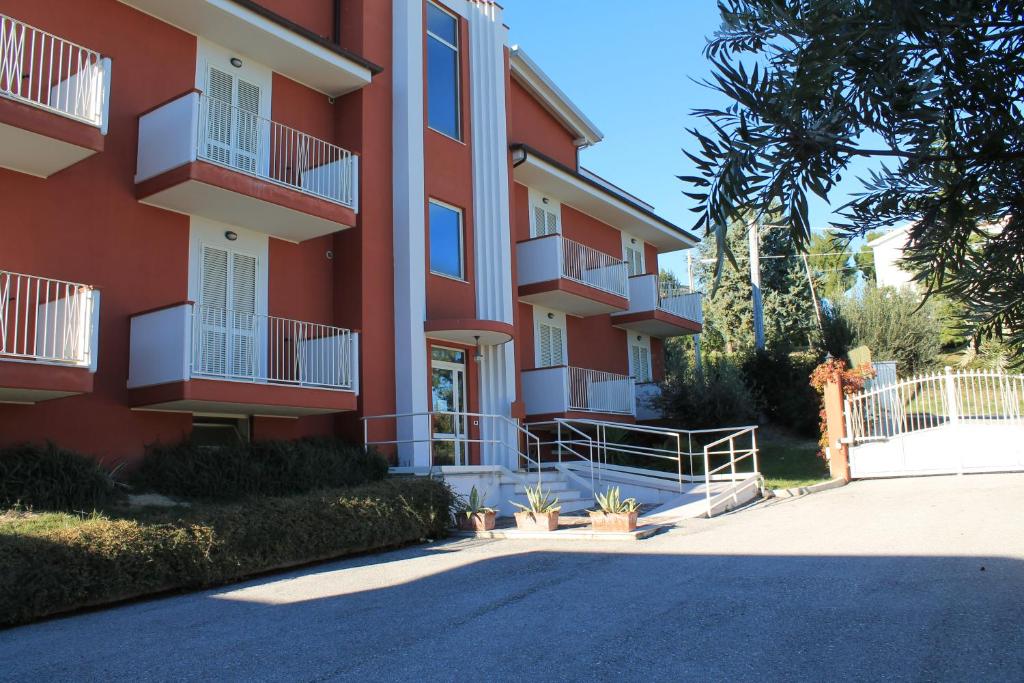 - un bâtiment rouge avec des balcons blancs dans une rue dans l'établissement Appartamento IL POGGIO, à Tortoreto Alto