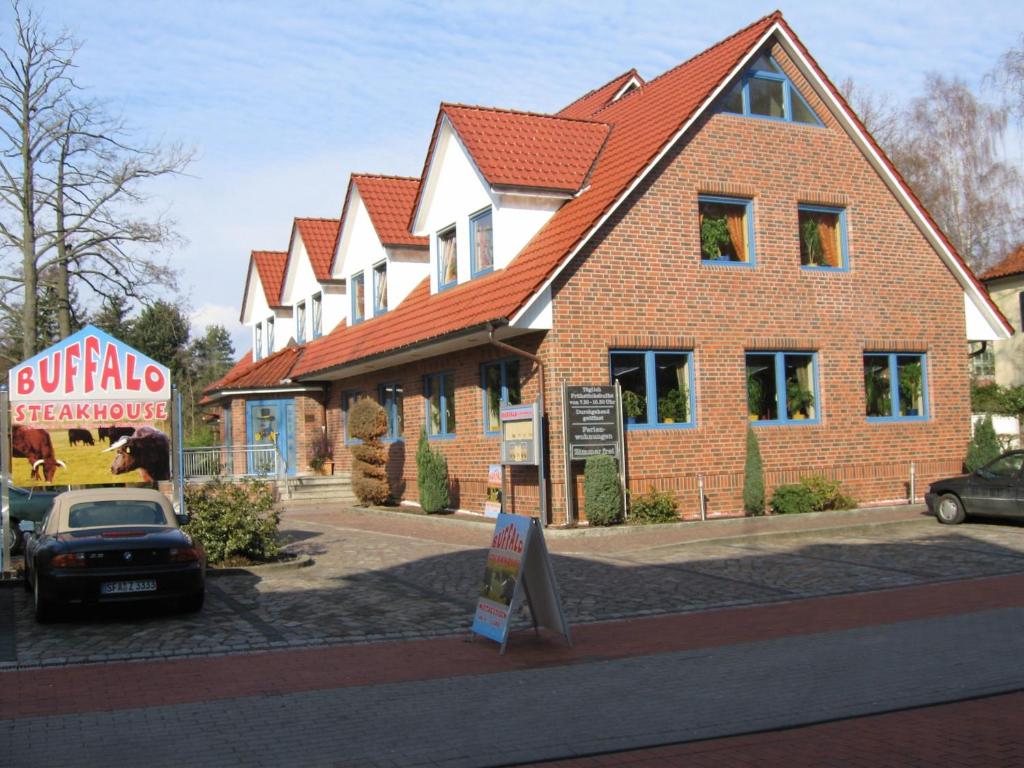 una gran casa de ladrillo con un cartel delante en Hotel MyLord en Soltau