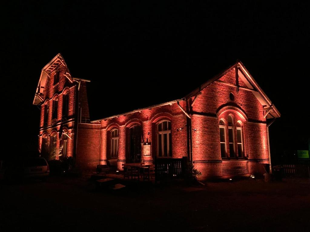 an old church lit up in red at night at Ferienwohnung im alten Bahnhof in Tribsees