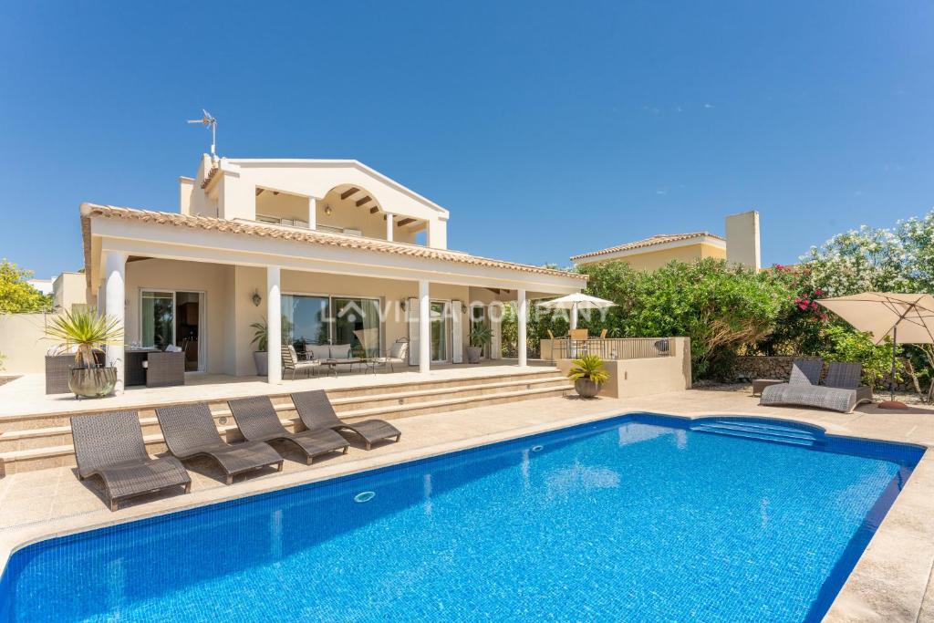 a villa with a swimming pool and a house at Villa Mala Bay in Mahón