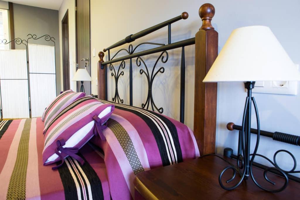 a bedroom with a bed with a table with a lamp at Casamary Buhardilla in Pontevedra