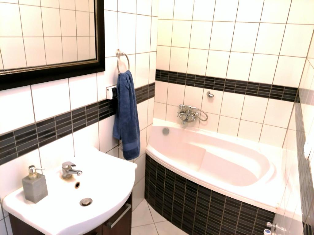 een badkamer met een wastafel en een bad bij mieszkanko w centrum Iławy in Iława