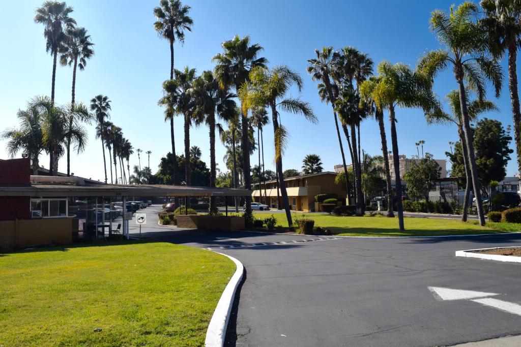 a parking lot with palm trees and a building at Hotel Palmeras Chula Vista in Chula Vista