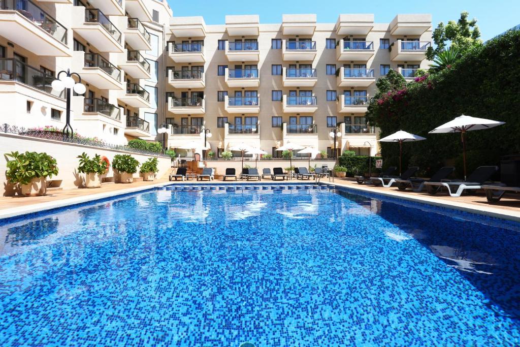 a large swimming pool in front of a building at Apartamentos Jade in Playa de Palma