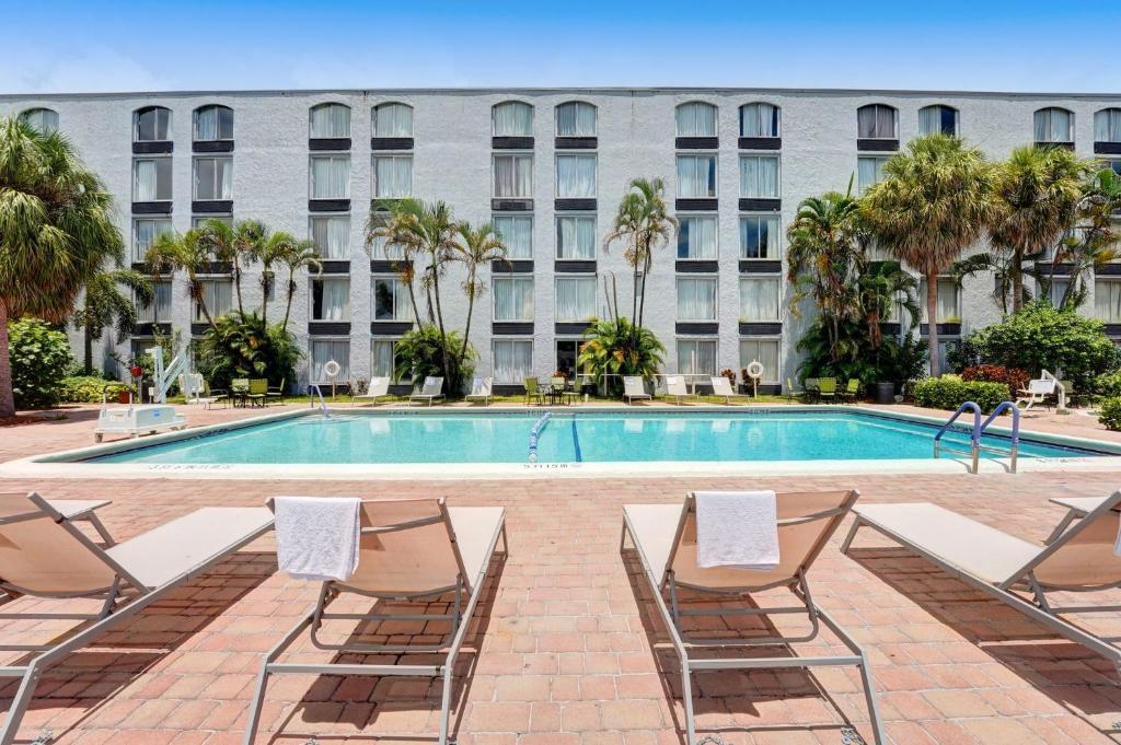 uma piscina com espreguiçadeiras e um edifício em Plaza Hotel Fort Lauderdale em Fort Lauderdale