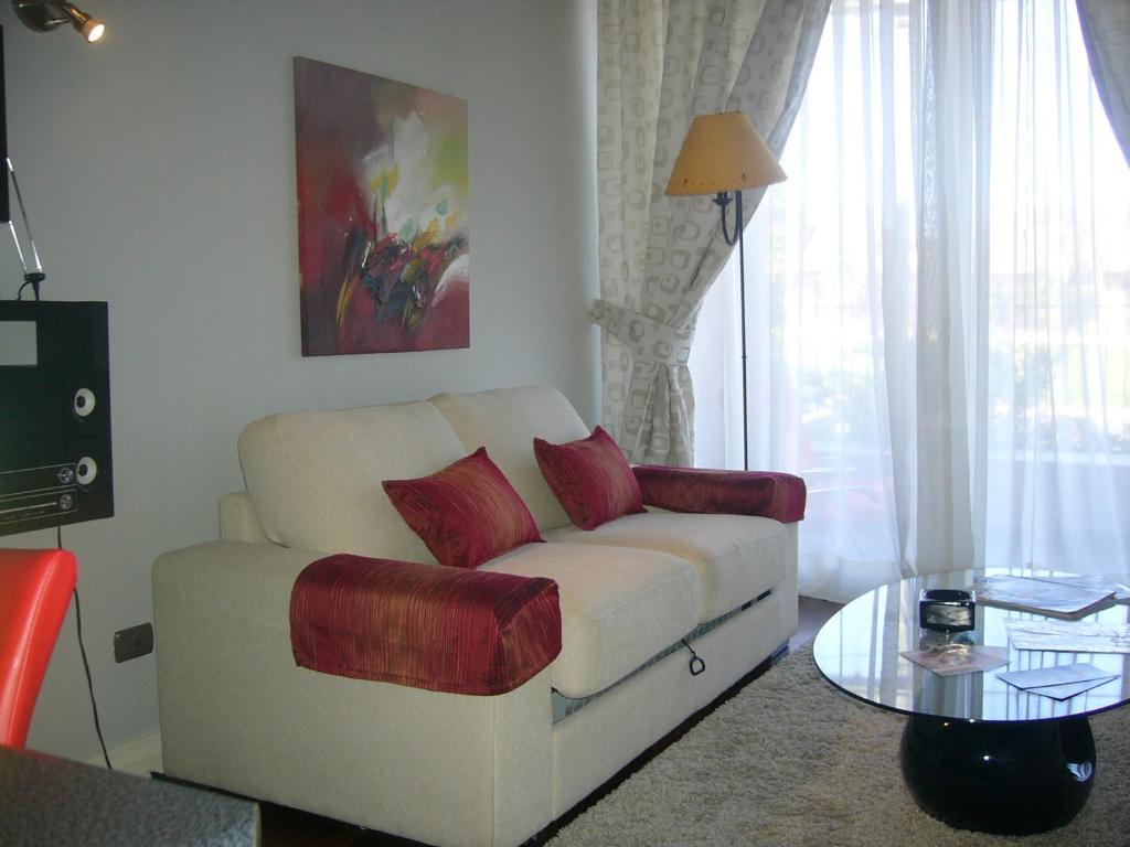 een woonkamer met een witte bank en een tafel bij Apart las Rastras talca in Talca