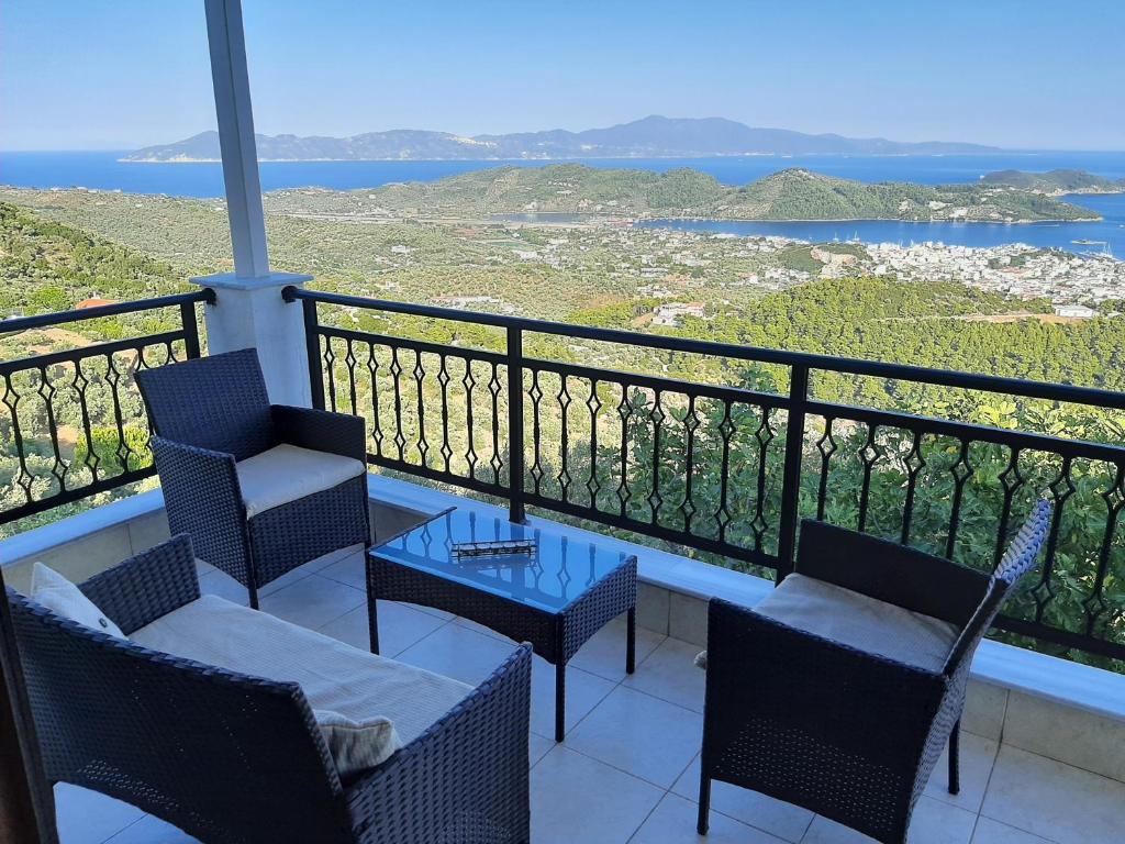 a balcony with chairs and a table and the ocean at Stathi's House in Megali Ammos