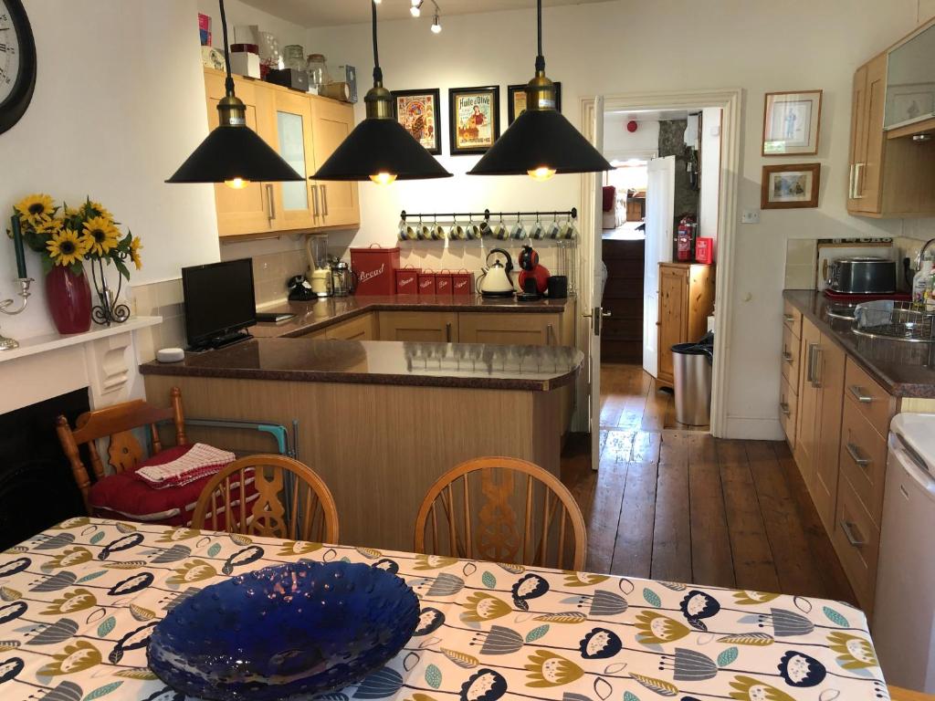 a kitchen and dining room with a table with a blue plate on it at 3 Bedroom 2 Bathrooms Apartment in Central Penzance in Penzance