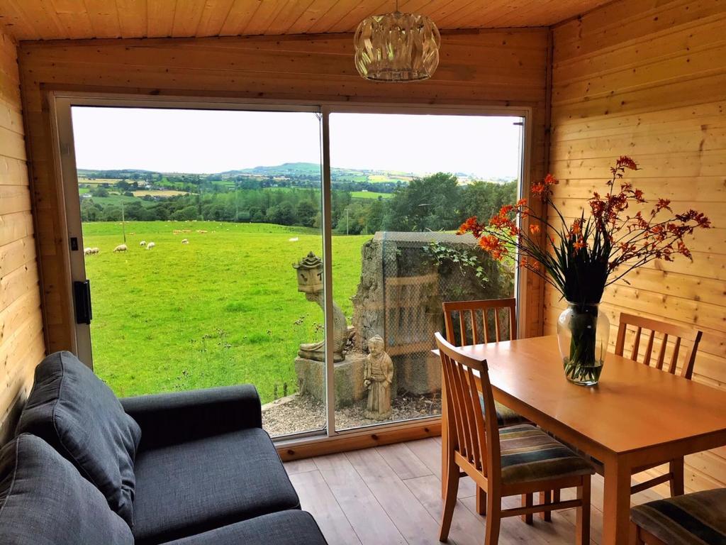 a living room with a table and a large window at Elagh View Bed & Breakfast in Derry Londonderry