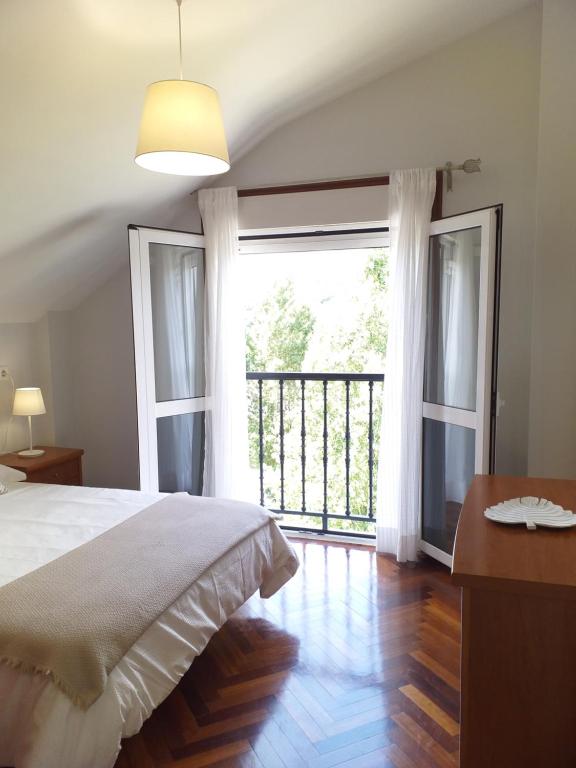 1 dormitorio con cama y ventana grande en El balcón de Padrón, en Padrón