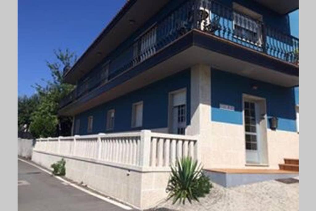 ein blau-weißes Gebäude mit einem Balkon in der Unterkunft Casamary in Pontevedra