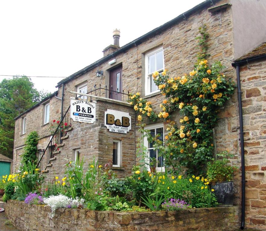 un edificio de ladrillo con flores delante en Hazels Roost B&B en Bainbridge