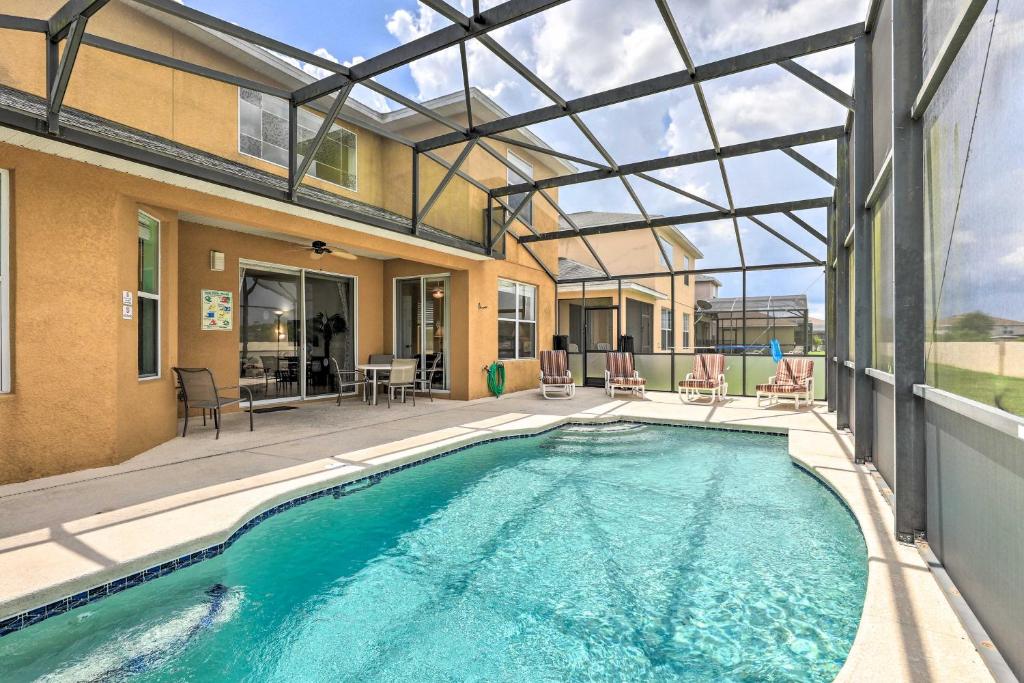 una piscina con patio e una casa di Colorful Family Villa with Game Room, 8 Mi to Disney a Kissimmee