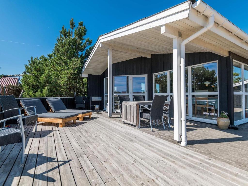 a wooden deck with chairs and a pavilion at Holiday home Fanø CLVIII in Fanø