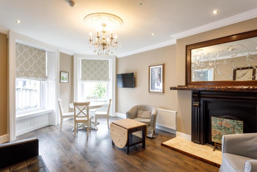 a living room with a fireplace and a table and chairs at Molloys Apartments in Dublin