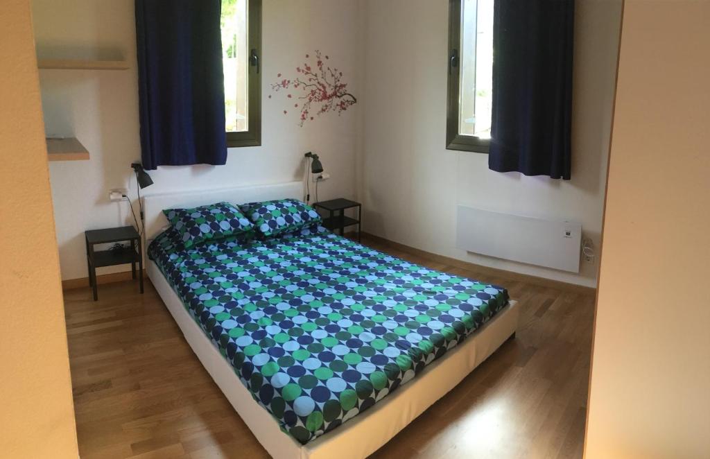 una camera da letto con un letto con lenzuola blu e due finestre di Apartamento 3 habitaciones en Pla de la Ermita - Aut a Pla de l'Ermita