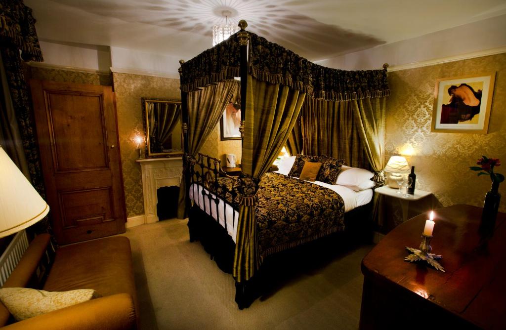 The Old Registry guest house في هاوورث: غرفة نوم بسرير مظلة وغرفة معيشة
