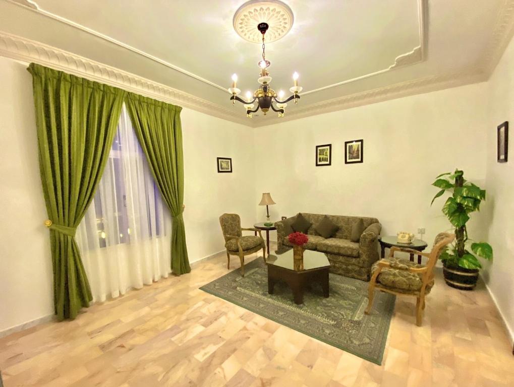 a living room with a couch and chairs and a chandelier at Rotana Residence Apartments in Jeddah