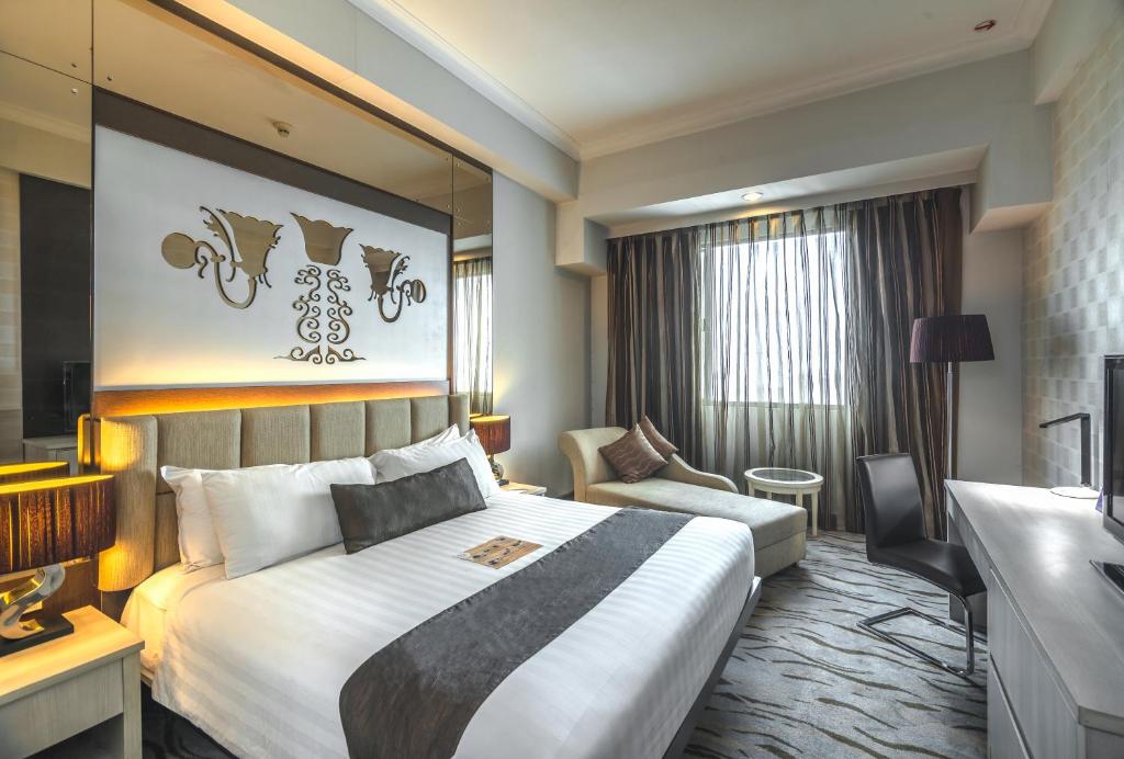 a hotel room with a large bed and a couch at Verwood Hotel and Serviced Residence in Surabaya