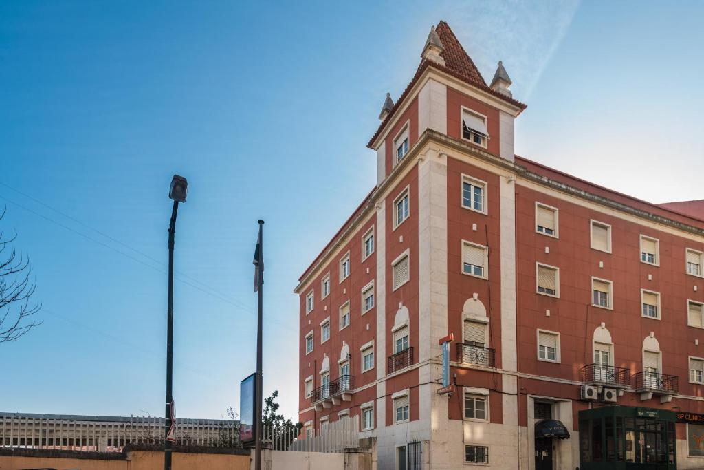 a large brick building with a tower on top of it at Apartamentos Lux Dinastia in Lisbon