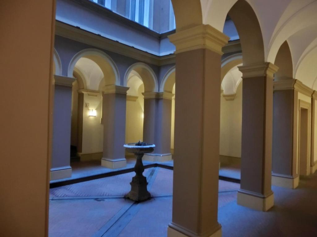 a room with columns and a fountain in a building at House Trevi in Rome