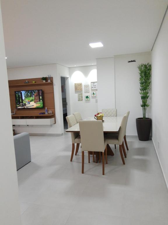 a white living room with a table and chairs at Apartamento com vista pro mar próximo ao Beto Carrero in Penha