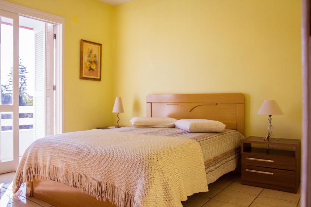 um quarto com uma cama com duas almofadas em Marili Apartamentos em Torres