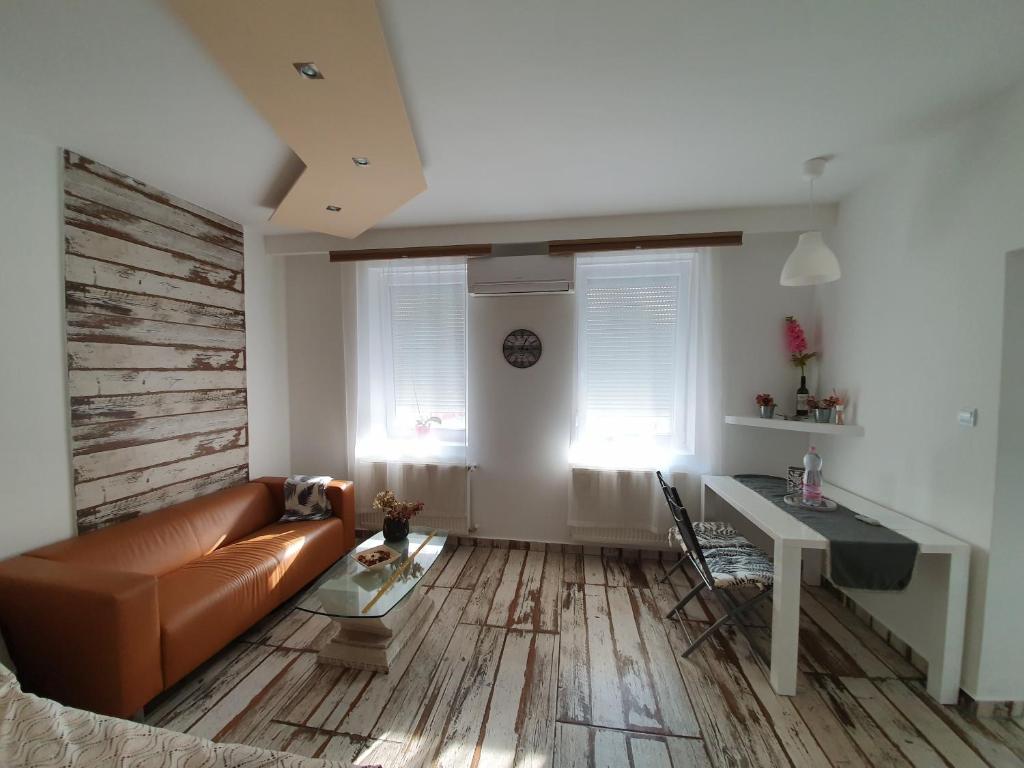 salon z kanapą i stołem w obiekcie Cozy apartment in the heart of Kecskemet w mieście Kecskemét