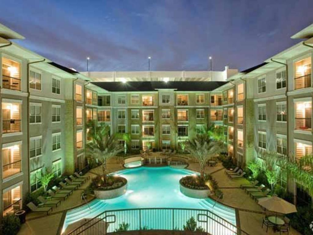 an apartment building with a pool in the courtyard at Gorgeous Furnished Apartments near Texas Medical Center & NRG Stadium in Houston