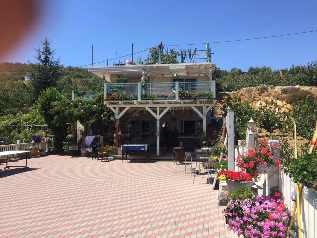 a building with a balcony with flowers on a patio at Paradise House in Majdal Shams