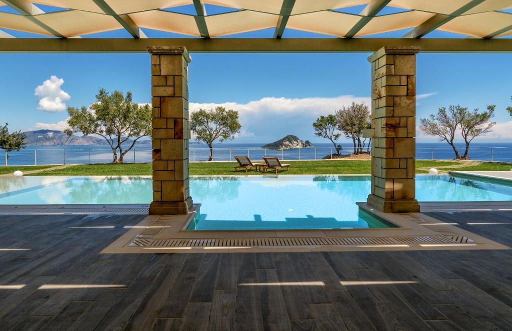 ケリオンにあるArtina Luxury Villaの水辺の景色を望むスイミングプール