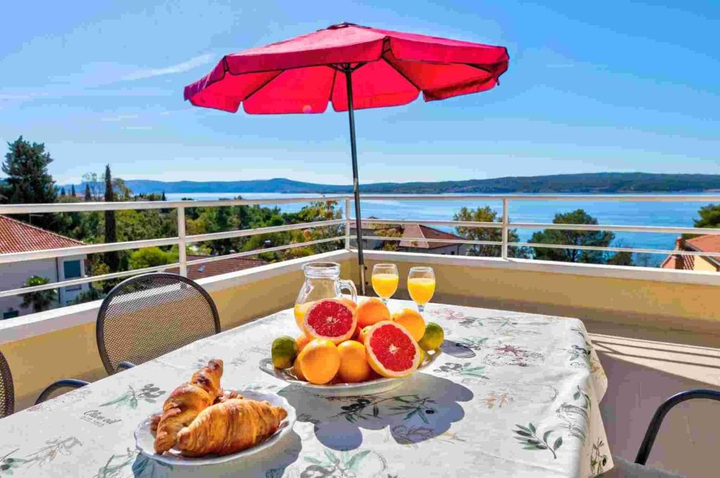 a table with a plate of fruit and a table with an umbrella at Apartment in Crikvenica 14104 in Sopaljska
