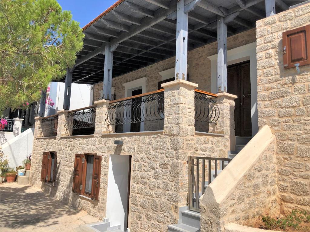 Casa de piedra con balcón en la parte superior. en Stone House Halki en Halki