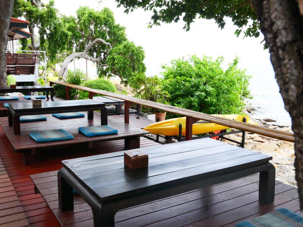 a group of picnic tables on a deck near the water at Vimarn Samed Resort in Ko Samed