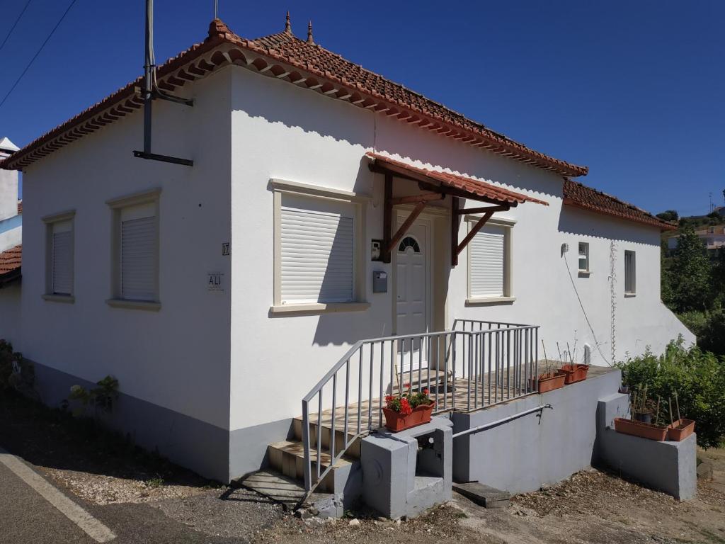 Biały dom z gankiem i drzwiami w obiekcie Casa 4 Estaçoes w mieście Batalha
